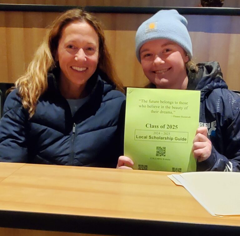 A parent and student holding up a Class of 2025 Local Scholarship Guide.