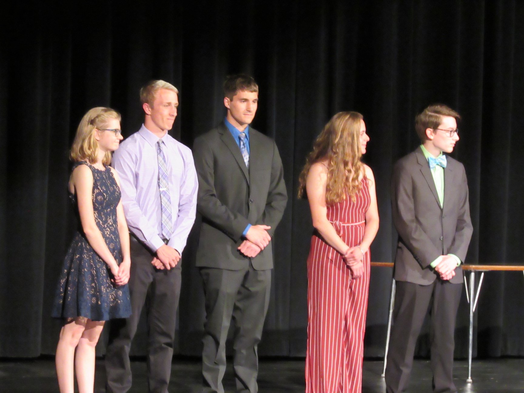 Students on stage waiting to presented with scholarships